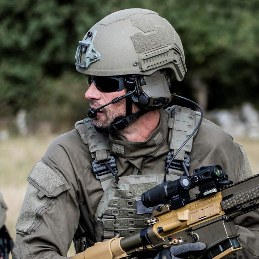 3M PELTOR ComTac headset worn with a helmet outdoors.